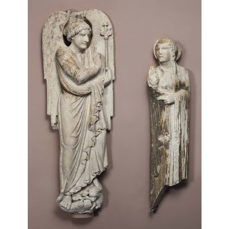 Deux statues en pierre. représentant la scène biblique de l'Annonciation. L'une, côté gauche, représente l'Ange, l'autre, à droite, représente la Vierge.