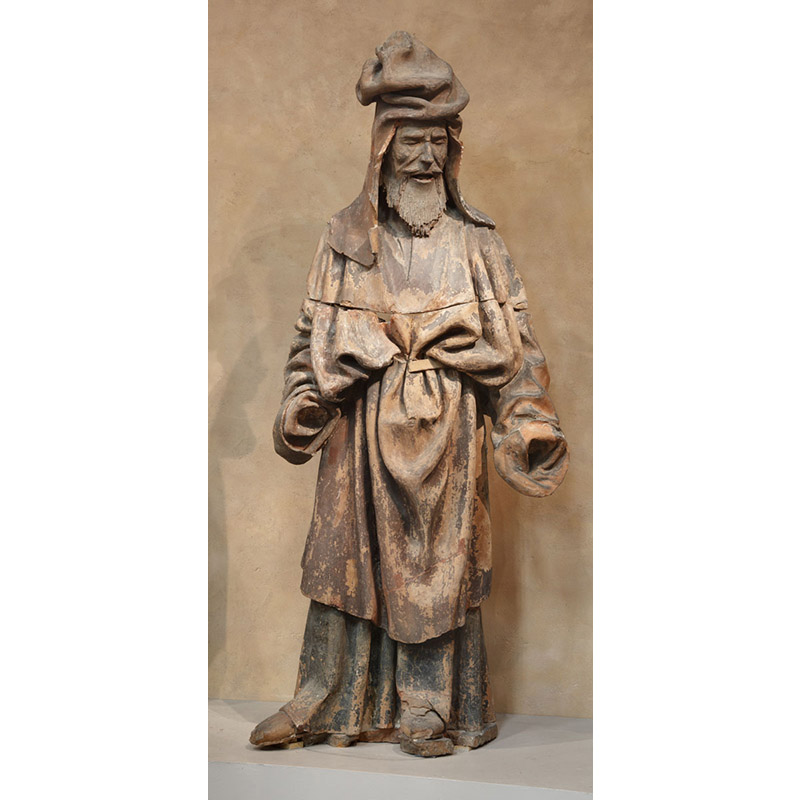 Personnage en terre cuite, un prophète (issu d'un ensemble de 7 personnages), à taille humaine, barbu, habillé d'une ample tunique et la tête surmontée d'un haut chapeau imposant avec de longs rabats.