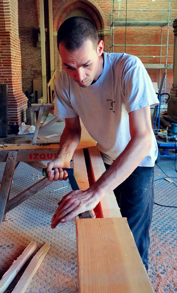 L'artisan prépare un élément de charpente